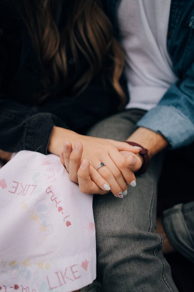 A close-up of a young couple holding hands, symbolizing love and togetherness.