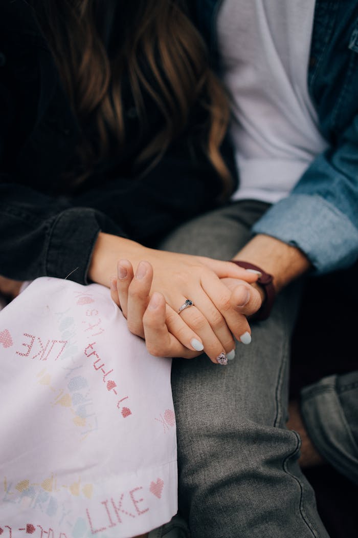 A close-up of a young couple holding hands, symbolizing love and togetherness.